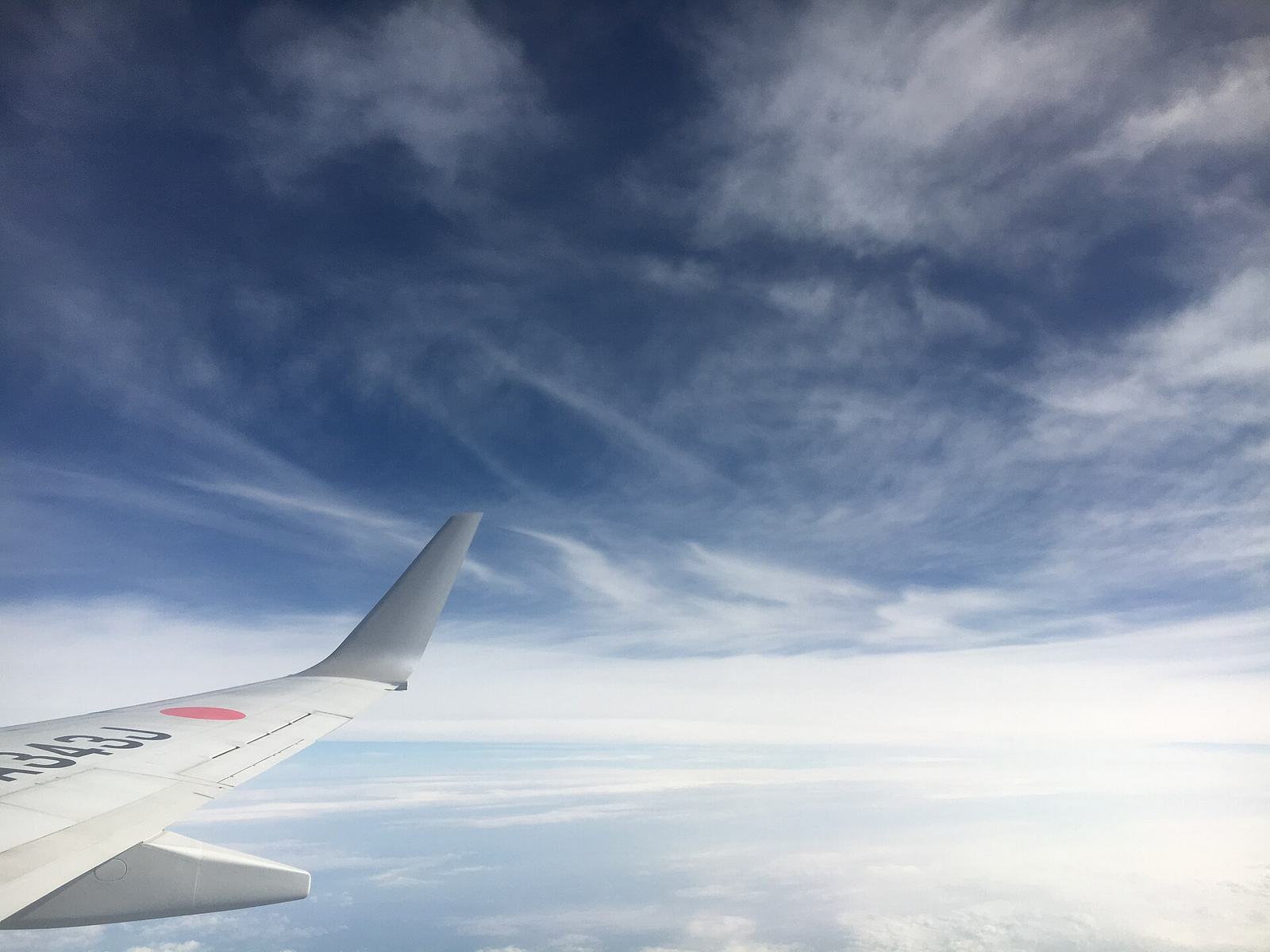 雲の上を飛ぶ機体の翼